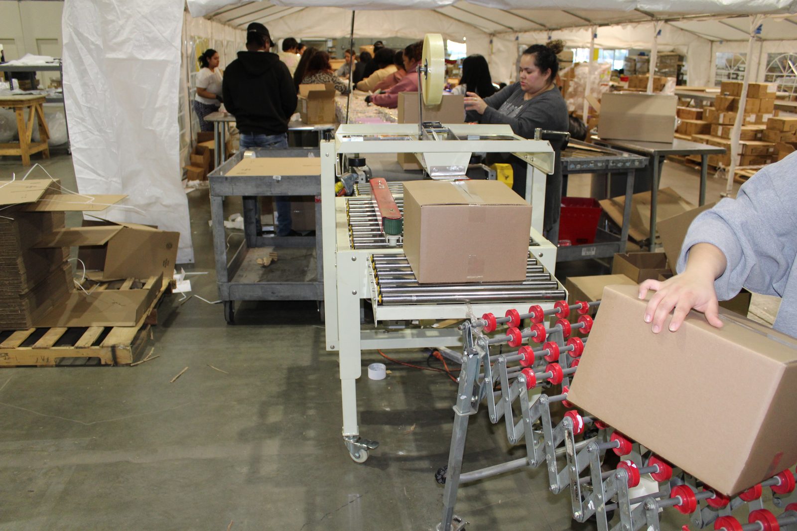 Assembly line with box sealing equipment and conveyor system at Productiv Charlotte warehouse
